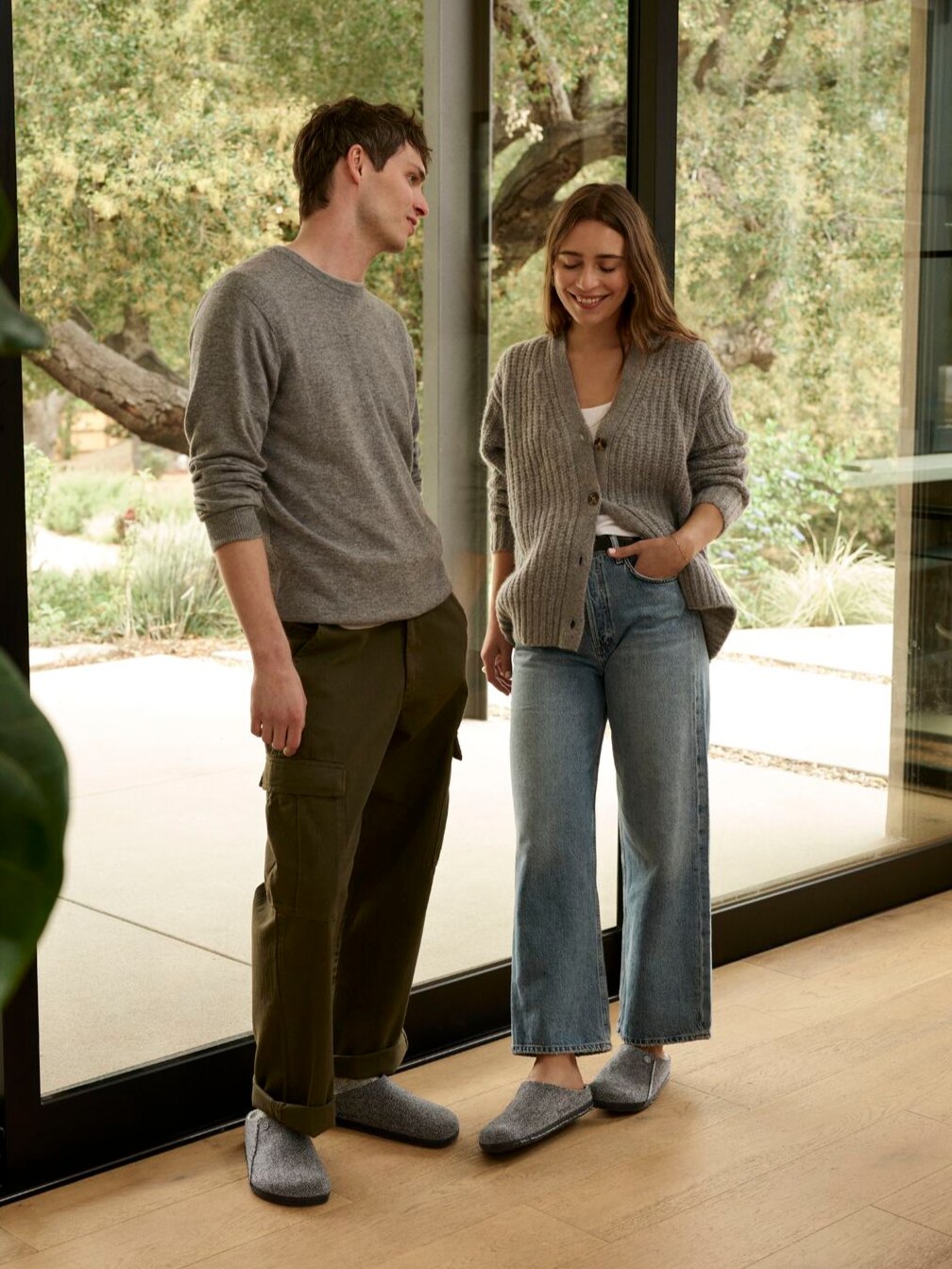 young man and woman standing by window wearing gray zermatt slippers