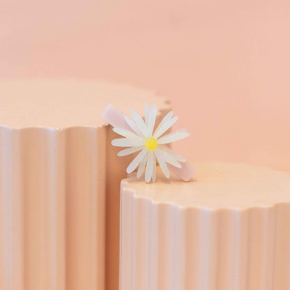 White daisy flower on a pink and beige striped background