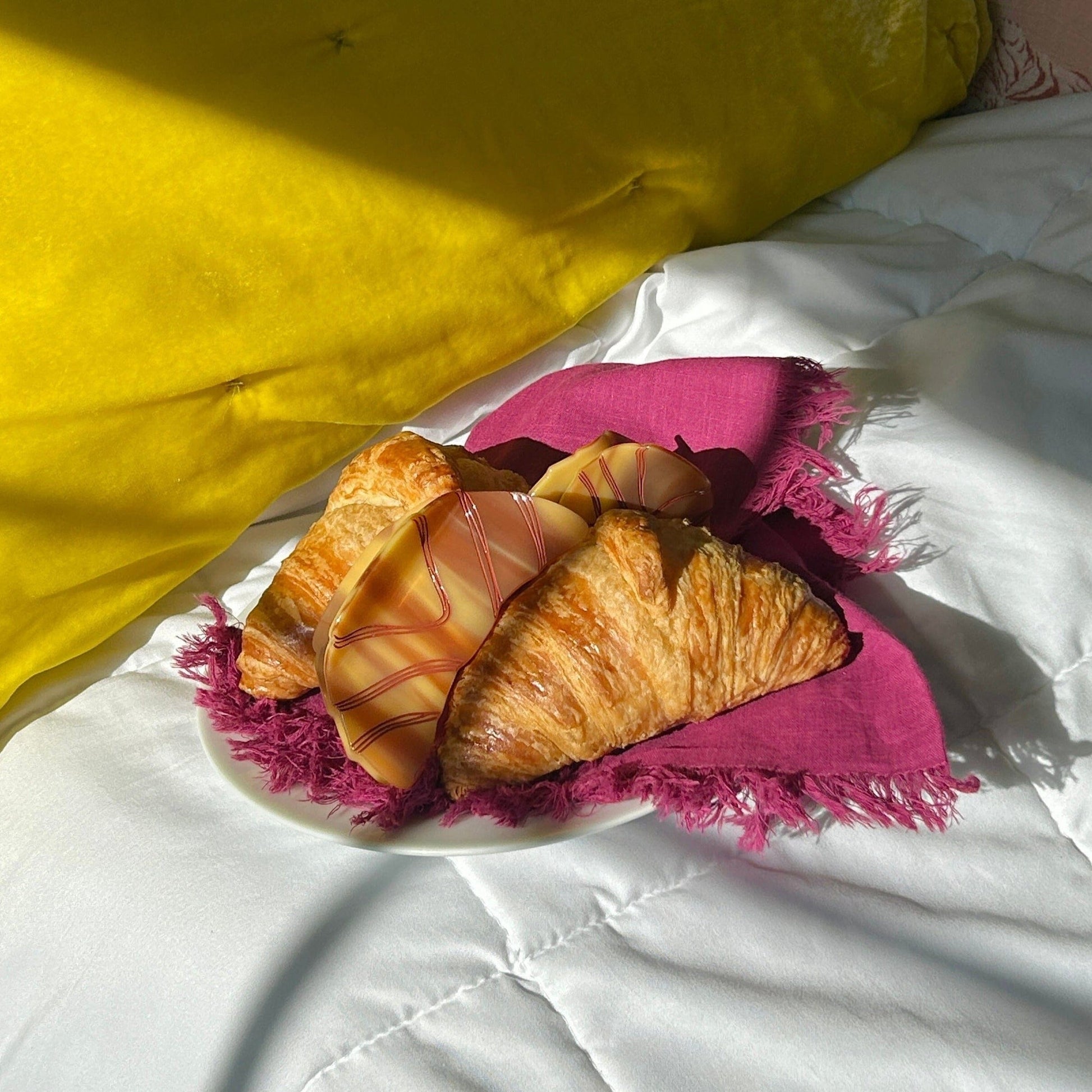 Pastries on a plate with a pink cloth on a white surface