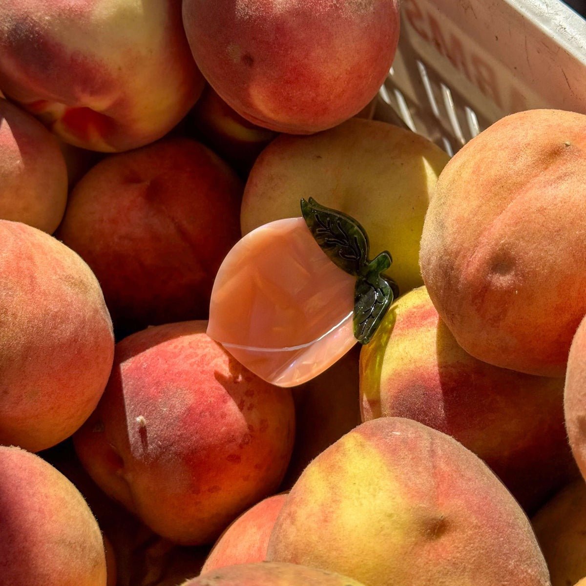 Close-up of peaches with a visible brand name on a white container.