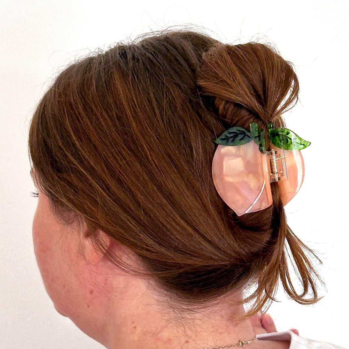 Person with a decorative hair clip in their hair on a white background