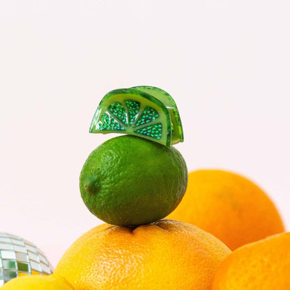 Green lime and orange with a decorative green leaf on a white background