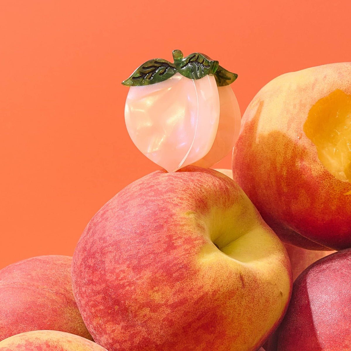 Peaches with a focus on texture and color against an orange background